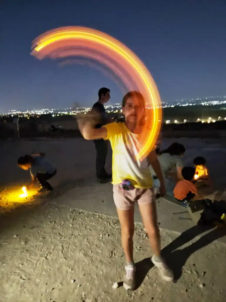 ילדה מסובבת עששית בלילה